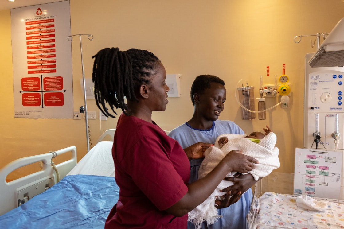 A nurse accompanies a young mother with her baby in the maternity ward of the Aga Khan Hospital in Kisumu, Kenya. AKDN / Lucas Cuervo Moura