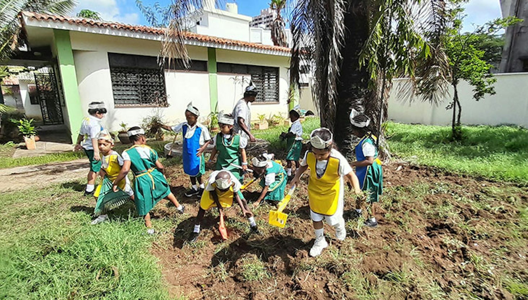 Young children clear the garden to make space to plant vegetables.