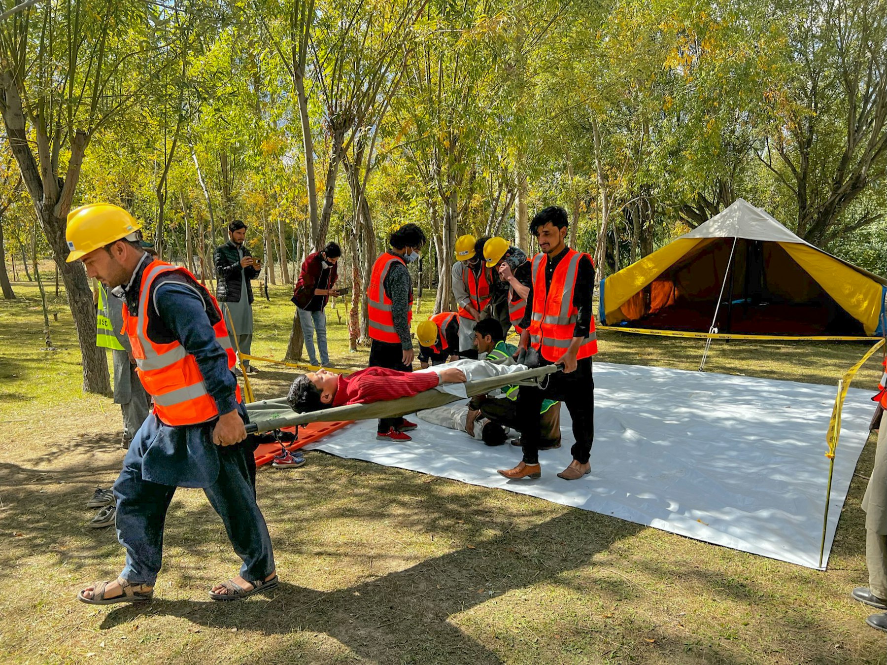 Community emergency response volunteers carry out a simulation using a stretcher.