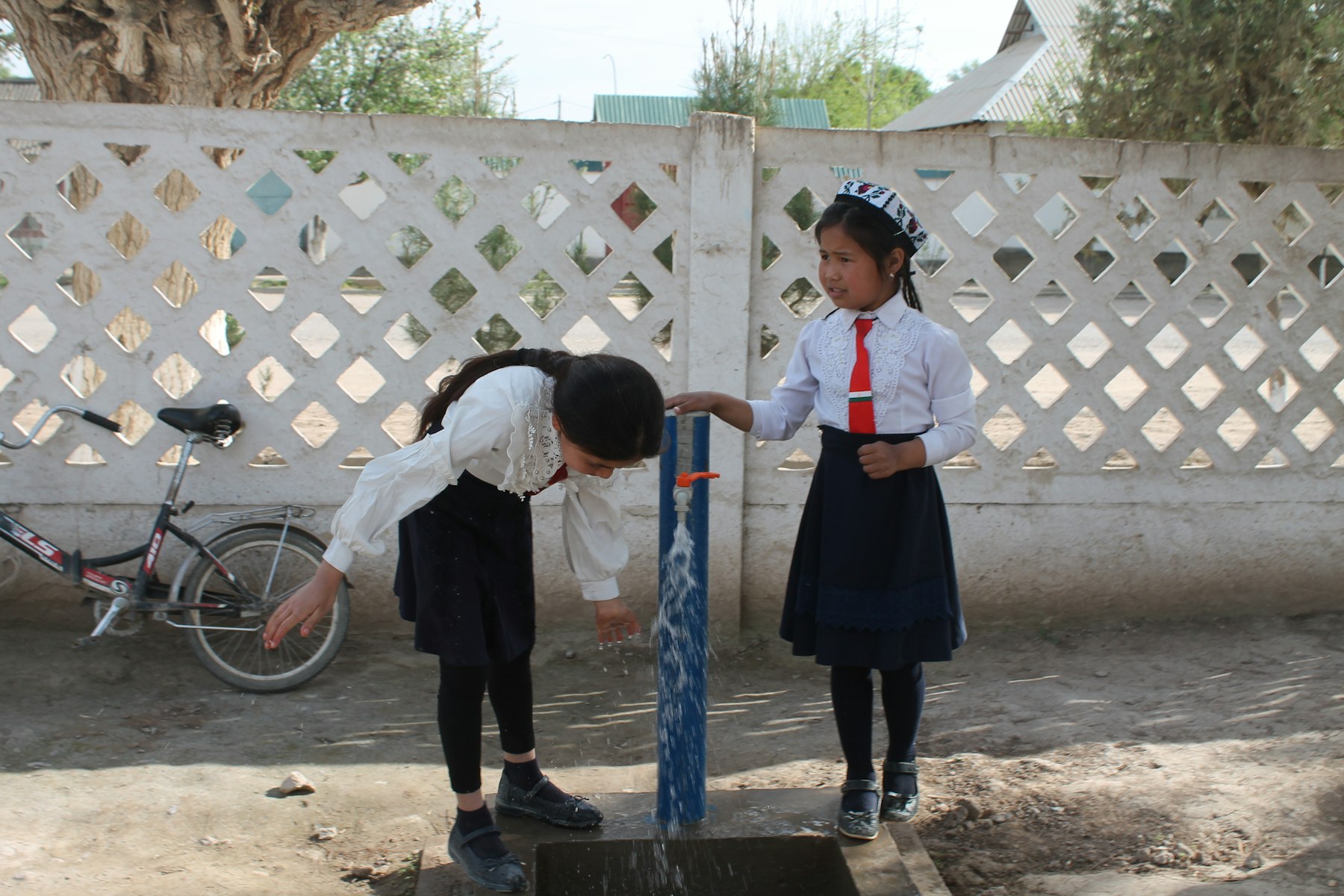 Schoolgirls use a tap in Surkhob Village, Farkhor District, Khatlon.