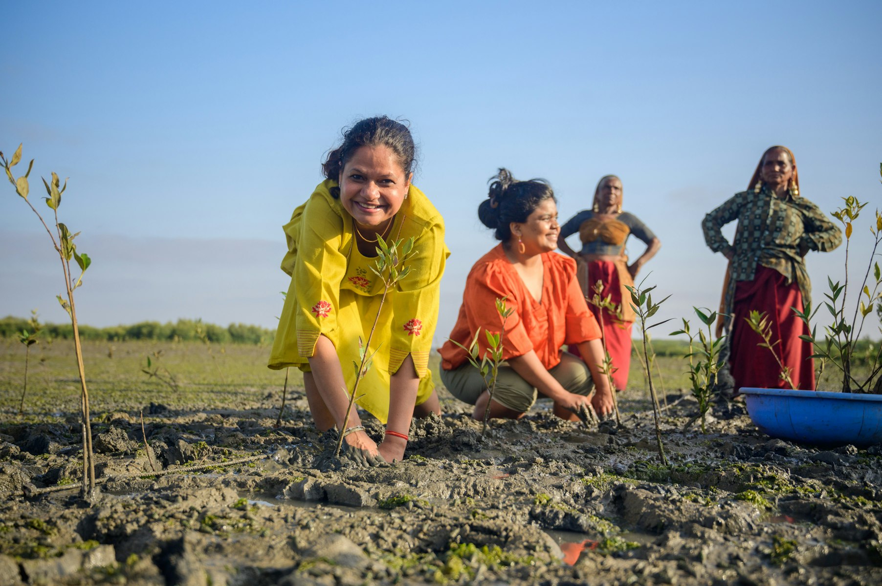 Ericsson and AKAH staff join a women’s self-help group in in Miyani Village, Porbandar to plant mangroves.